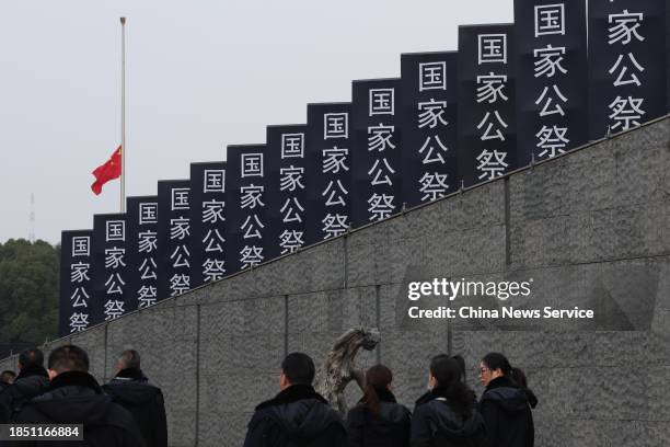 China's national flag flies at half mast during the state memorial ceremony for China's National Memorial Day for Nanjing Massacre Victims at the...