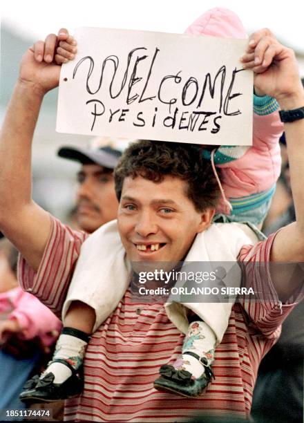 Young man, with his daughter, holds a sign welcoming the President of Spain, Jose Maria Aznar in Tegucigalpa, Honduras, 13 November 1999. Un joven...