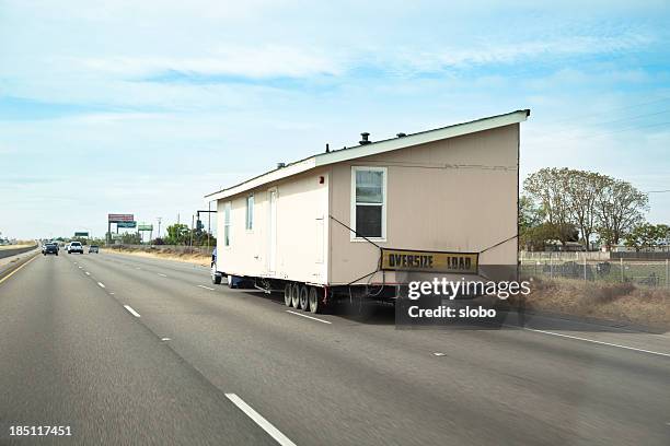 einer einseitigen campingwagen auf rädern abgeschleppt von einem lkw. - mobile home stock-fotos und bilder