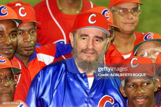 Cuban President and honorary coach Fidel Castro , surrounded by his team, smiles late 18 November 1999 after a friendly game between ball veterans...
