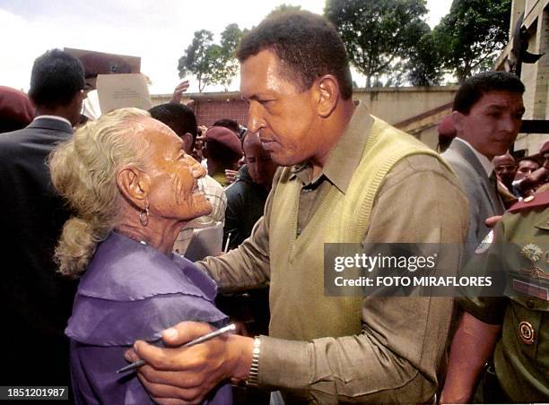 Venezuelan President Hugo Chavez Frias hugs a woman during a meeting in Caracas 29 August 1999. El Presidente venezolano Hugo Chavez Frias abraza a...