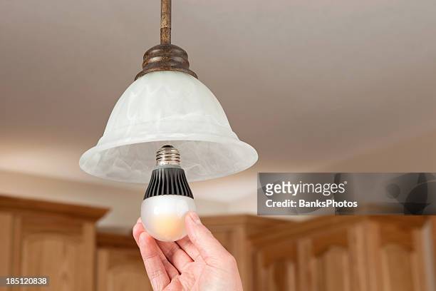 mains installer led ampoule - led lampe photos et images de collection