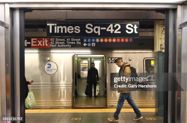 Person walks along a platform as a train at the Times Square - 42nd Street subway station waits to depart on December 12 in New York City.