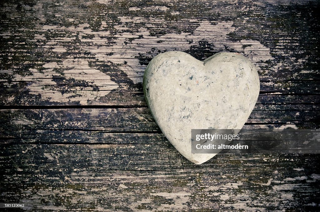 A stone in the shape of a heart on a wooden surface