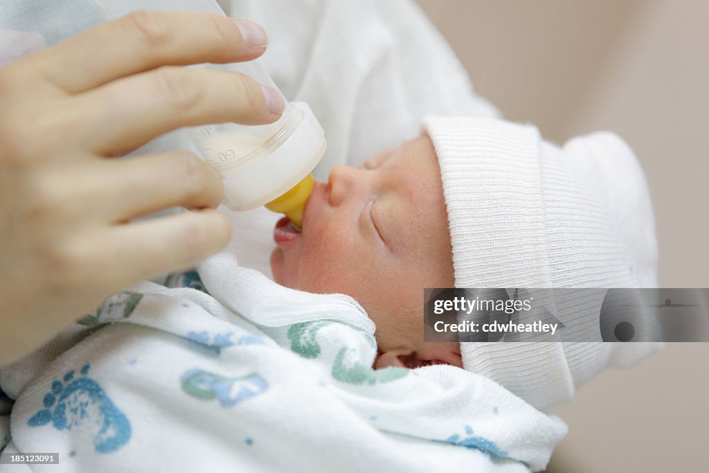 Mother bottle feeding her premature baby in the hospital nursery