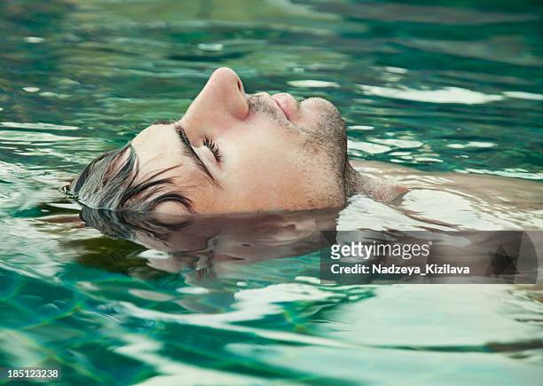 an image of a man with his eyes closed floating in water - drijven stockfoto's en -beelden