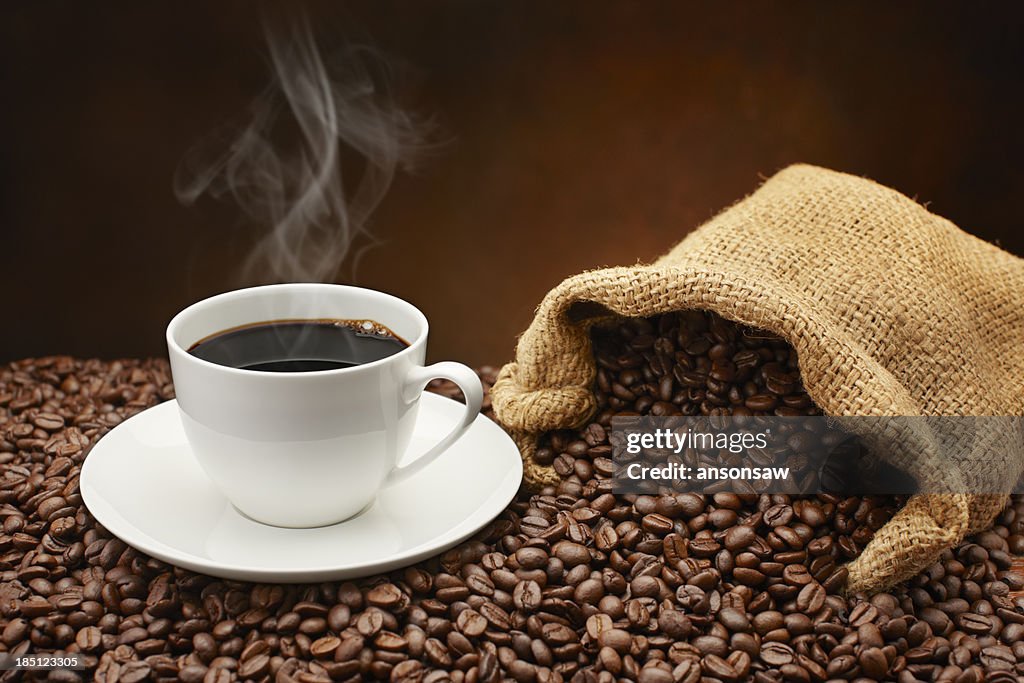Vapor Xícara de café na pilha de grãos de café