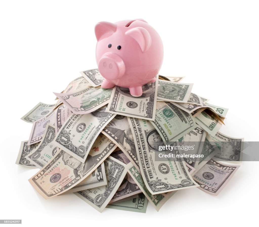 Pink piggy bank on pile of U.S. bills