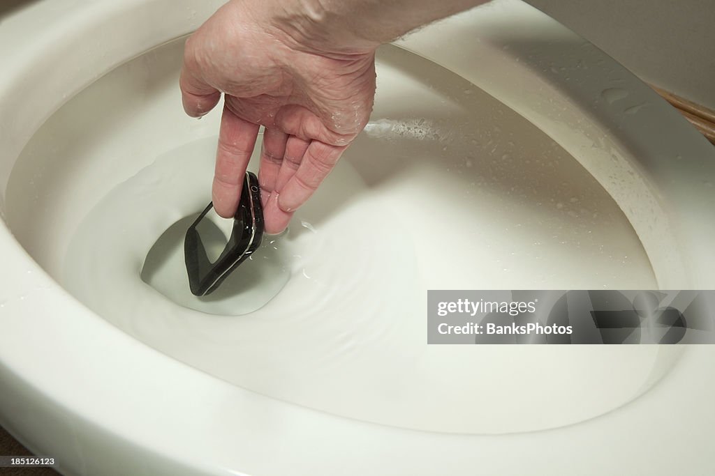 Hand Reaching into Toilet to Retrieve a Mobile Phone