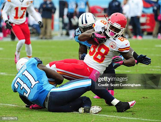 Junior Hemingway of the Kansas City Chiefs is tackled by Bernard Pollard and Moise Fokou of the Tennessee Titans at LP Field on October 6, 2013 in...