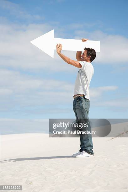 A Man Holding A Directional Arrow High-Res Stock Photo
