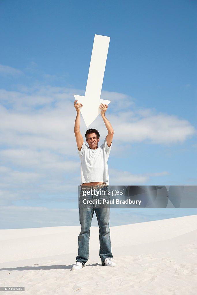 A man holding up a directional arrow