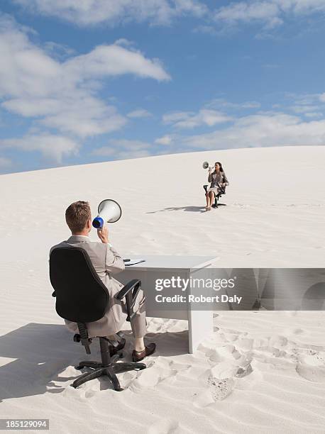 a businessman and businesswoman sitting on chair with using bullhorn - robert madden stock pictures, royalty-free photos & images