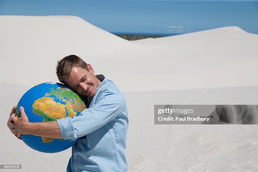 A man hugging a globe
