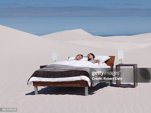 a couple sleeping in a bed outdoors - romantic young couple sleeping in bed stock pictures, royalty-free photos & images