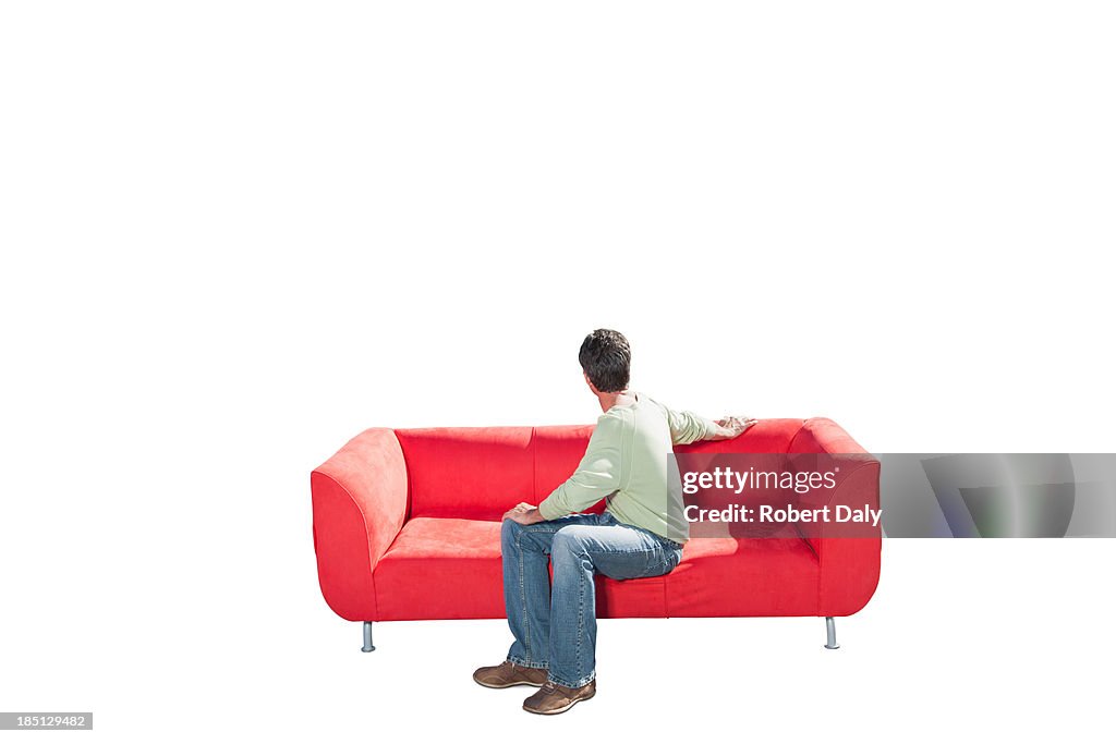 A man sitting on a couch and looking back