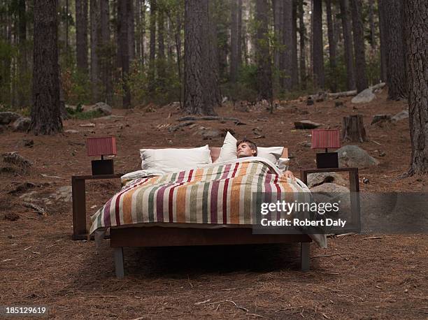 A Man Sleeping In A Bed Outdoors In The Woods, Foto de stock