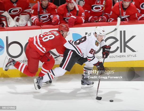 Ben Smith of the Chicago Blackhawks looks to pass the puck while Alexander Semin attempts of the Chicago Blackhawks to defend during their NHL game...