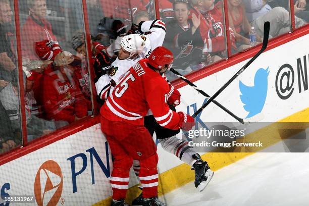 Tuomo Ruutu of the Carolina Hurricanes checkers Niklas Hjalmarsson of the Chicago Blackhawks during their NHL game at PNC Arena on October 15, 2013...