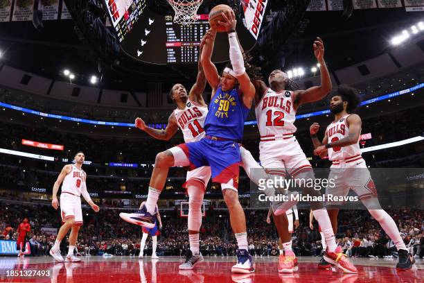 Aaron Gordon of the Denver Nuggets rebounds the ball against DeMar DeRozan and Ayo Dosunmu of the Chicago Bulls during the first half at the United...