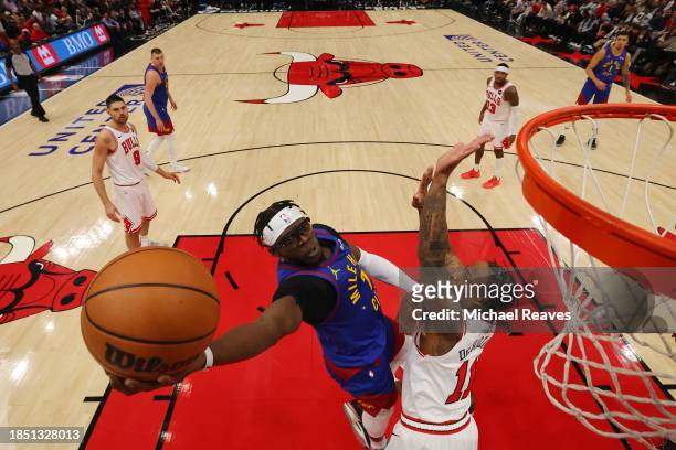 Reggie Jackson of the Denver Nuggets goes up for a layup against DeMar DeRozan of the Chicago Bulls at the United Center on December 12, 2023 in...