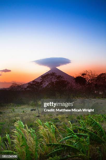 sunset falls behind the concepcion volcano - concepcion stock pictures, royalty-free photos & images