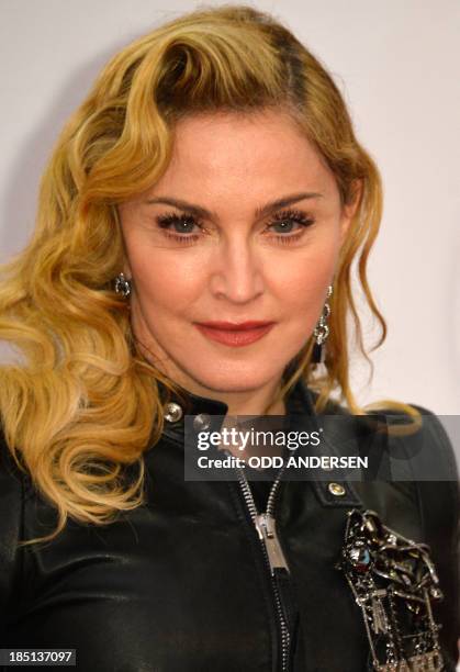 Pop star Madonna poses for photographers on the red carpet on the opening event of the Fitness Center "Hard Candy" on October 17, 2013 in Berlin. The...