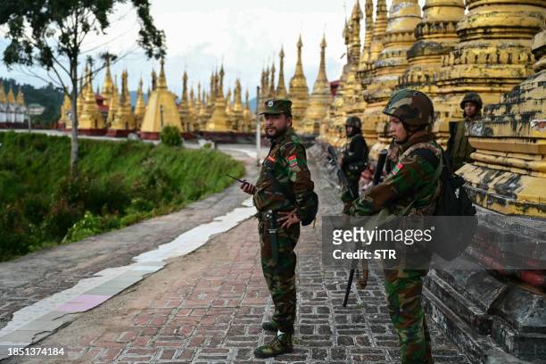 This photo taken on December 13, 2023 shows members of ethnic minority armed group Ta'ang National Liberation Army standing guard in a temple area of...
