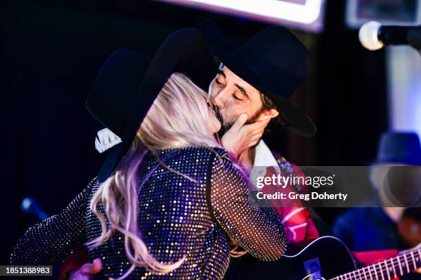 Hassie Harrison and Ryan Bingham on stage at the Bingham's Bourbon NFR After Party at Inspire at the Wynn on December 07, 2023 in Las Vegas, Nevada.