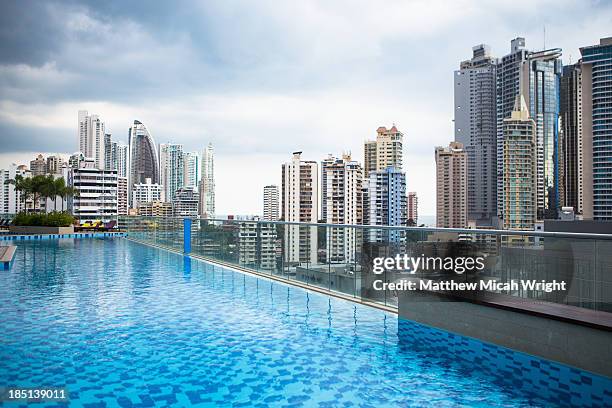 a poolside view overlooking the city skyline. - rooftop pool stock pictures, royalty-free photos & images