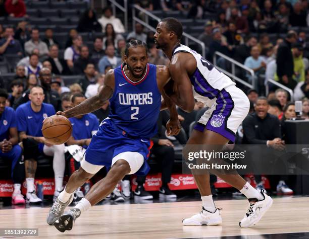 Kawhi Leonard of the LA Clippers drives to the basket past Harrison Barnes of the Sacramento Kings during the first half at Crypto.com Arena on...