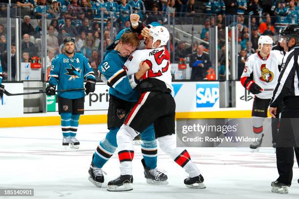 Matt Pelech of the San Jose Sharks and Chris Neil of the Ottawa Senators get into a fight at SAP Center on October 12 2013 in San Jose, California.