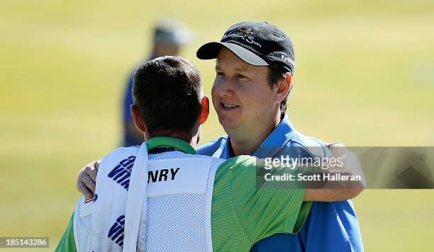 Henry hugs his caddie Don Donatello on the ninth green after finishing with an 11-under par 60 during the first round of the Shriners Hospitals for...