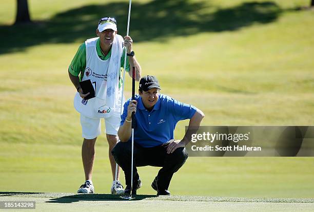 Henry lines up his eagle putt with his caddie Don Donatello on the ninth green during the first round of the Shriners Hospitals for Children Open at...