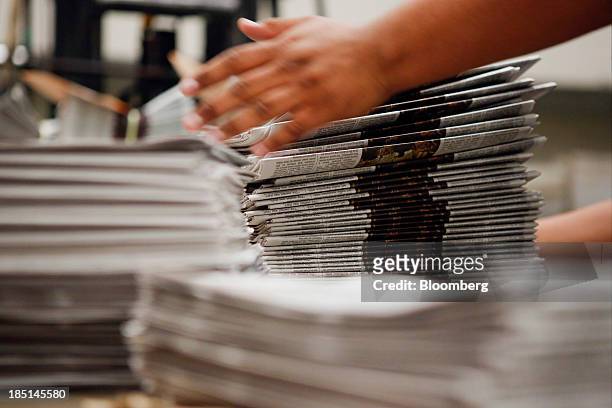 Worker stacks copies of the Los Angeles Times newspaper after printing at the Olympic Press facility in Los Angeles, California, U.S, on Wednesday,...