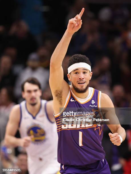 Devin Booker of the Phoenix Suns reacts after scoring against the Golden State Warriors during the second half of the NBA game at Footprint Center on...