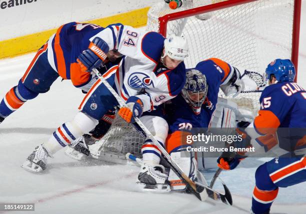 Ryan Smyth of the Edmonton Oilers tries to move the puck past goaltender Evgeni Nabokov of the New York Islanders at the Nassau Veterans Memorial...