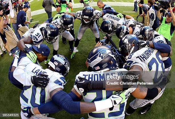 The Seattle Seahawks huddle before a game against the Arizona Cardinals at the University of Phoenix Stadium on October 17, 2013 in Glendale, Arizona.