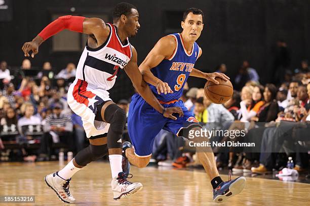 Pablo Prigioni of the New York Knicks drives against John Wall of the Washington Wizards during the pre-season game at the Baltimore Arena on October...