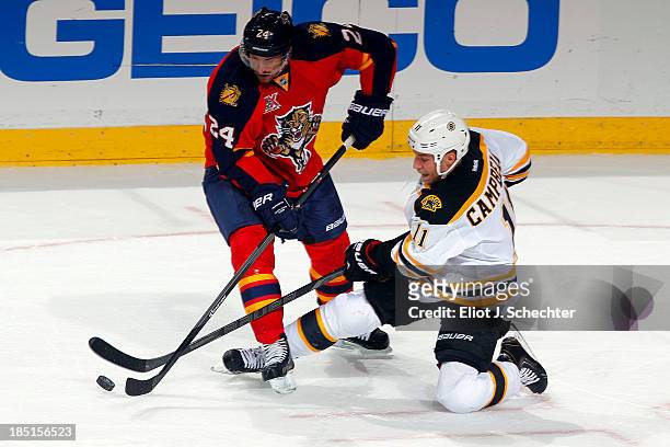 Brad Boyes of the Florida Panthers crosses sticks with Gregory Campbell of the Boston Bruins at the BB&T Center on October 17, 2013 in Sunrise,...