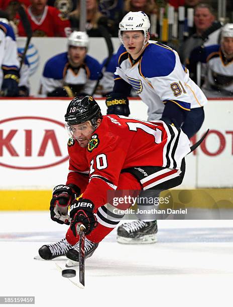 Patrick Sharp of the Chicago Blackhawks controls the puck chased by Vladimir Tarasenko of the St. Louis Blues at the United Center on October 17,...