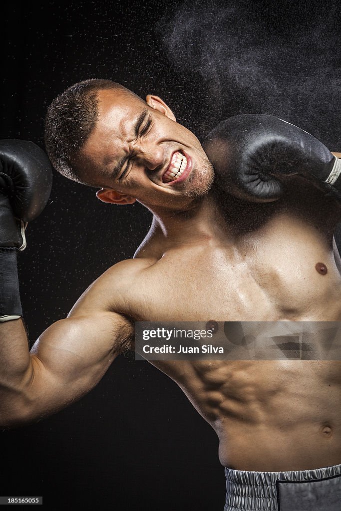 Male boxer getting punch in face.
