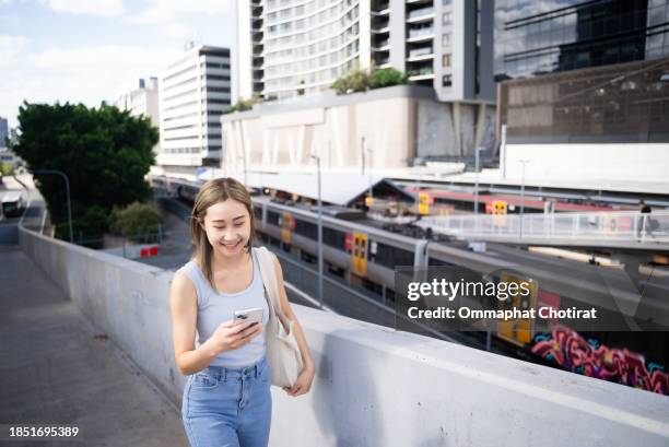 young asian smiling woman on the move with public transportation for sustainable lifestyles - train vehicle stock pictures, royalty-free photos & images