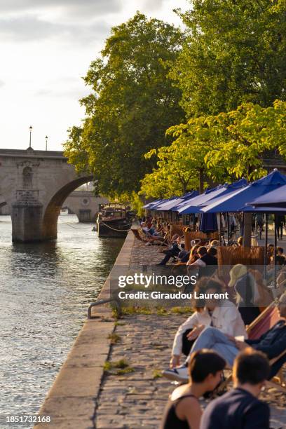 laurent giraudou / paris, the seine river, by the hotel de ville quay in summer during the paris plage scheme, - parasol de plage stock pictures, royalty-free photos & images