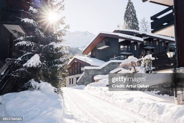 winter wonderland in a french alpine town covered in deep snow with sunlight. - chalet fotografías e imágenes de stock