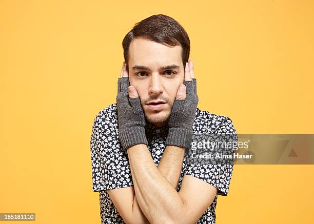man in fingerless gloves holding his face - fingerless glove stock-fotos und bilder