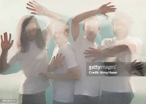 four men posing behind a silk sheet - blank t shirt model stock pictures, royalty-free photos & images