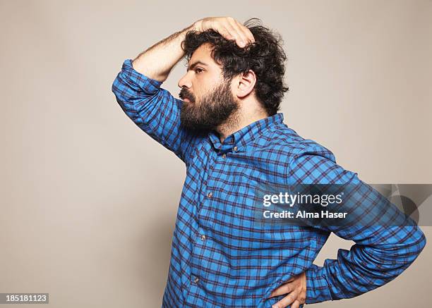 man in blue shirt with hand on head and hip - only mid adult men stock pictures, royalty-free photos & images