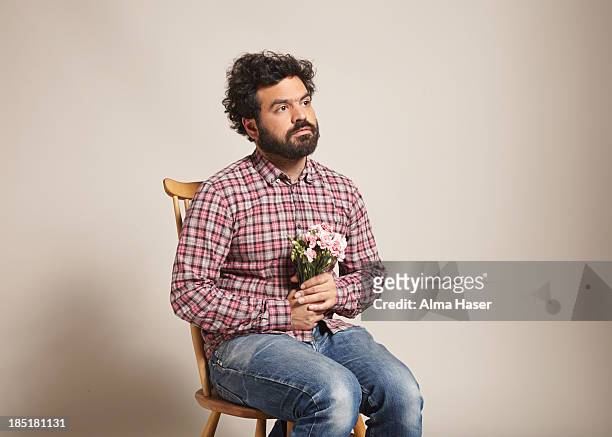 a man sitting with a bunch of pink carnations - three quarter length fotografías e imágenes de stock
