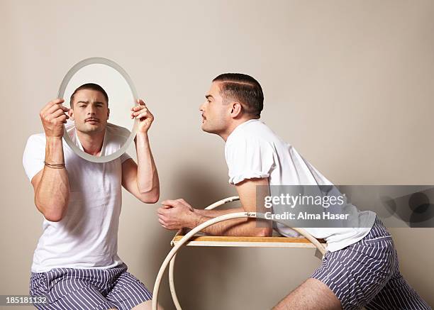 man looking at himself in the mirror held by a boy - vanidad fotografías e imágenes de stock